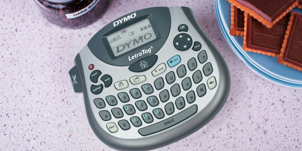 DYMO LetraTag label maker on a kitchen bench beside a labelled storage jar