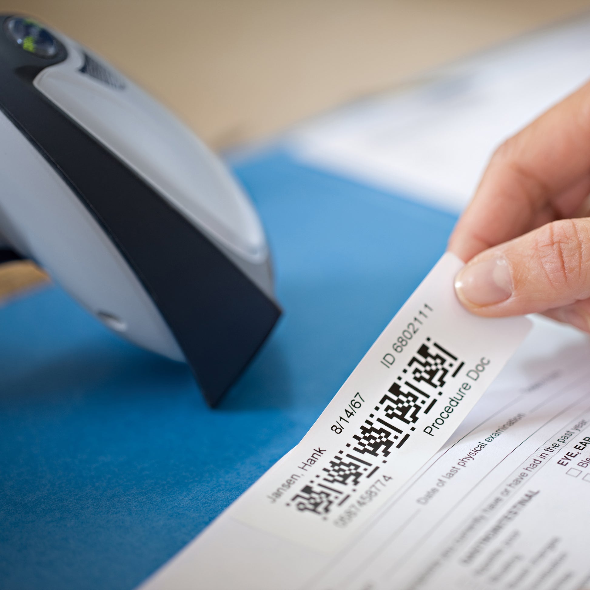 Printed address label being applied to a blue envelope
