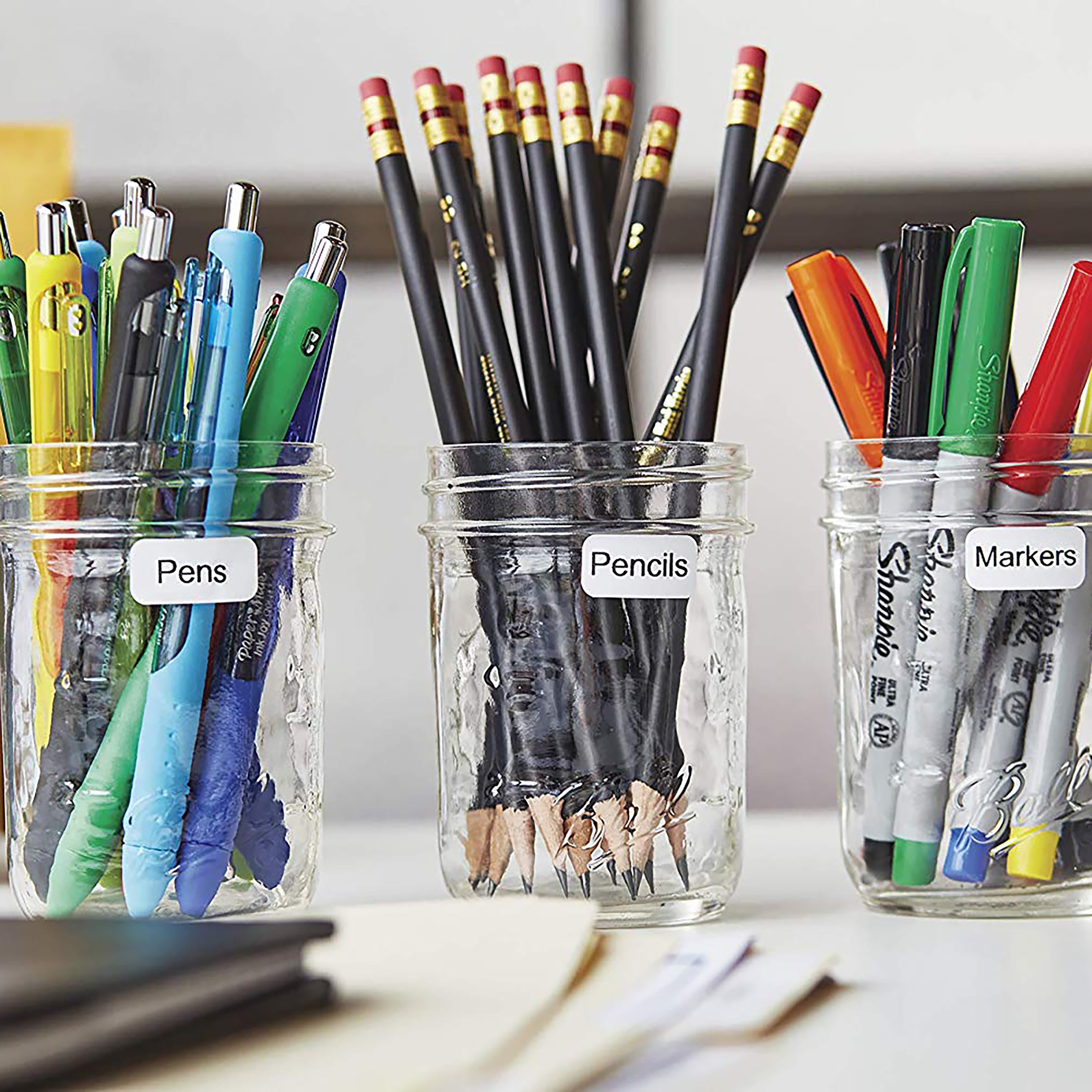 Labelled jars and containers holding paintbrushes and art supplies