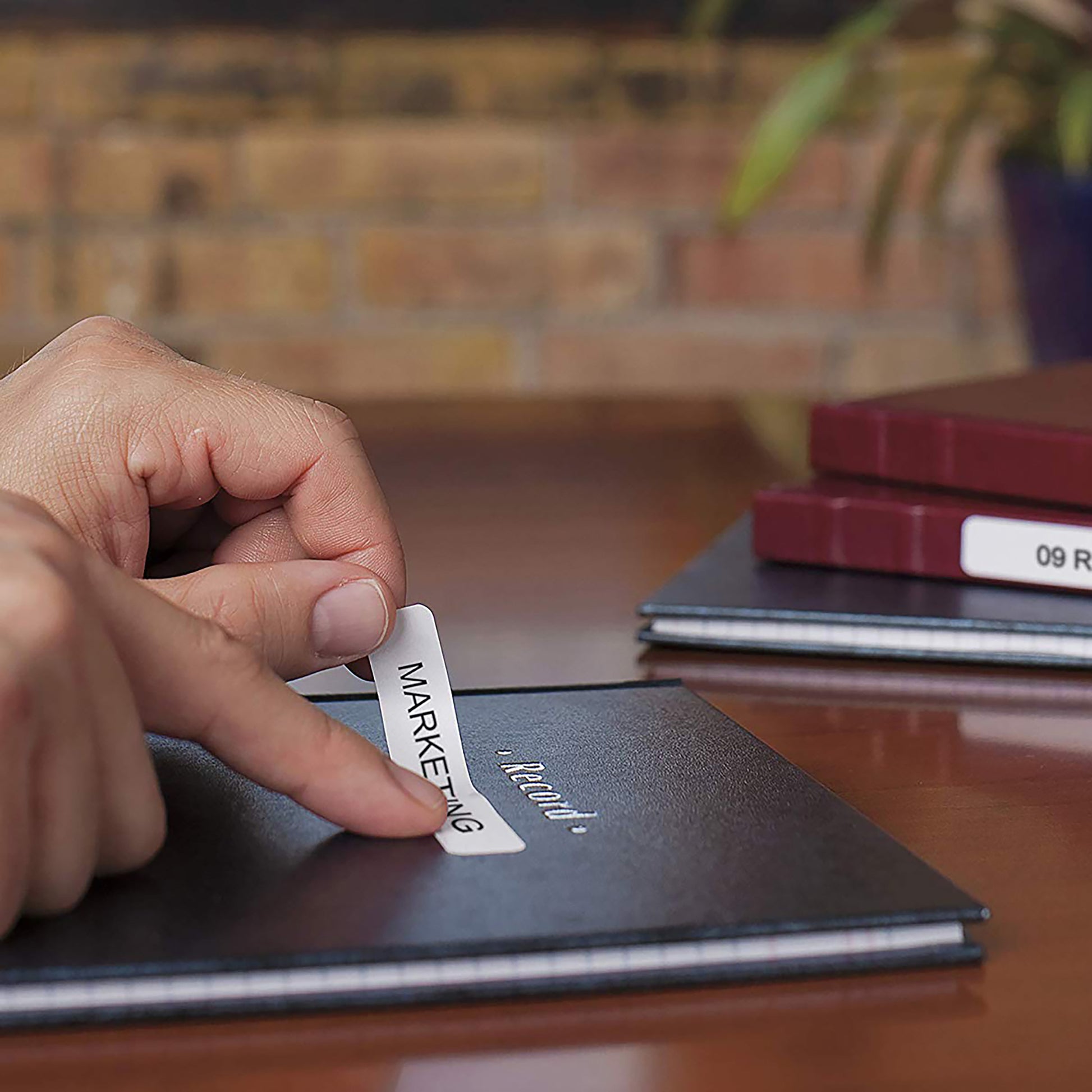 Hand applying a label to a tablet or electronic device