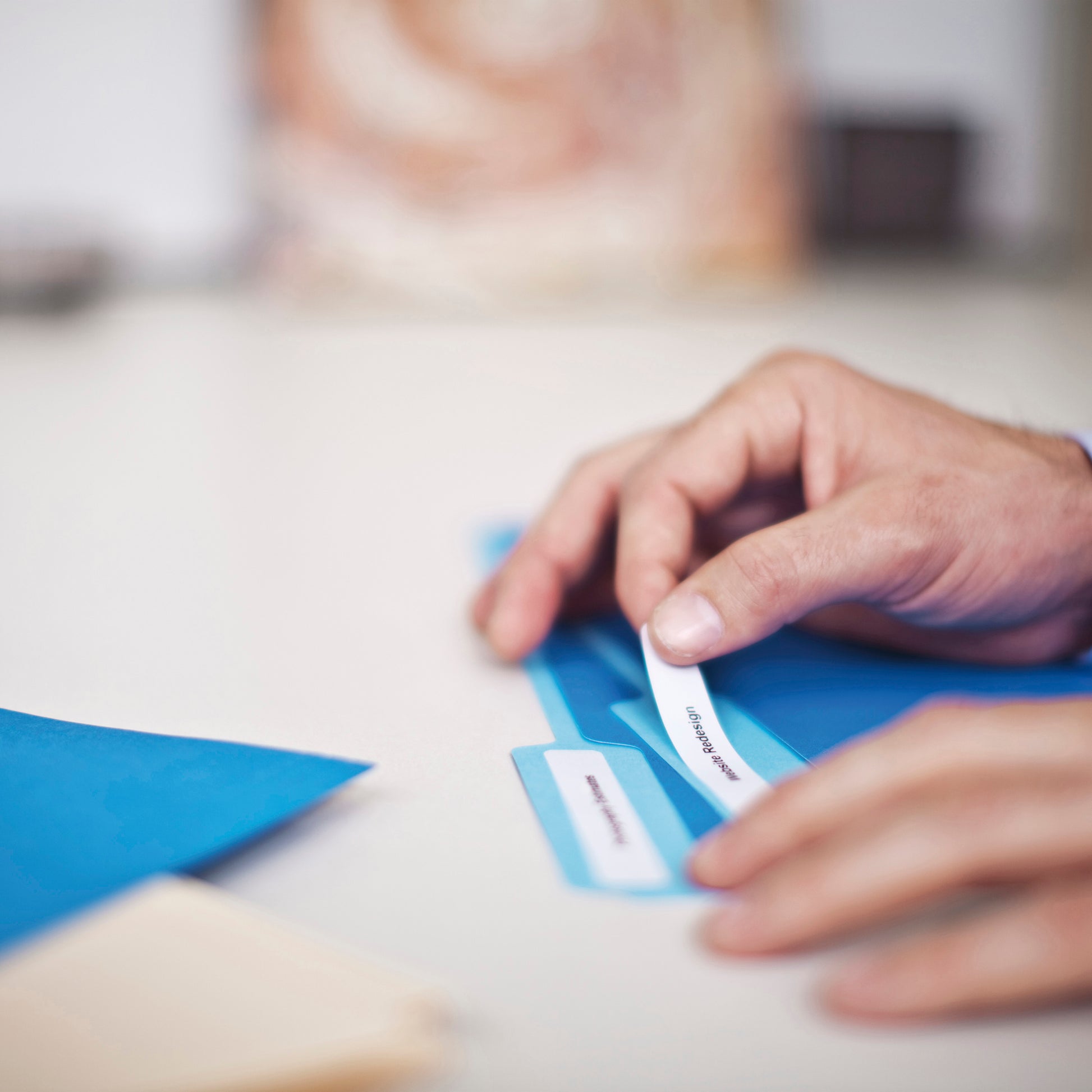 Person applying a label to a blue storage item