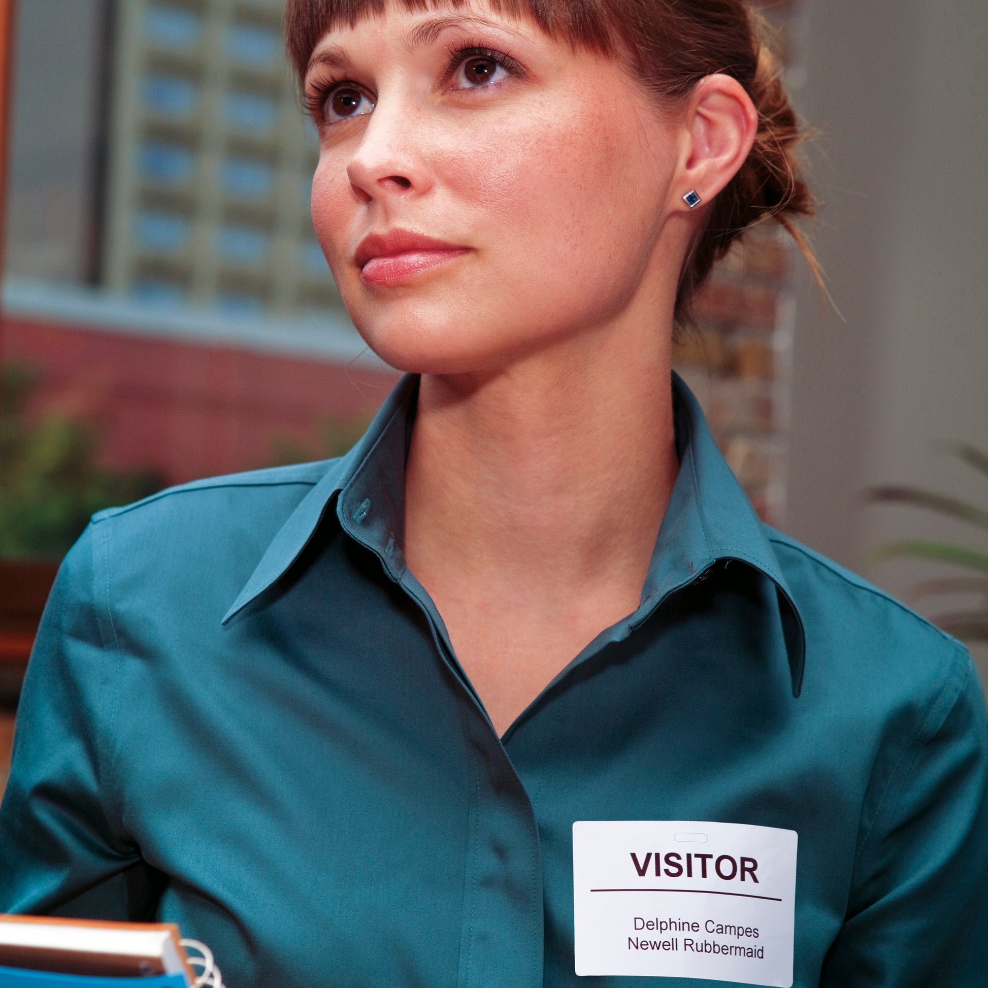 Delivery worker in teal uniform holding parcels