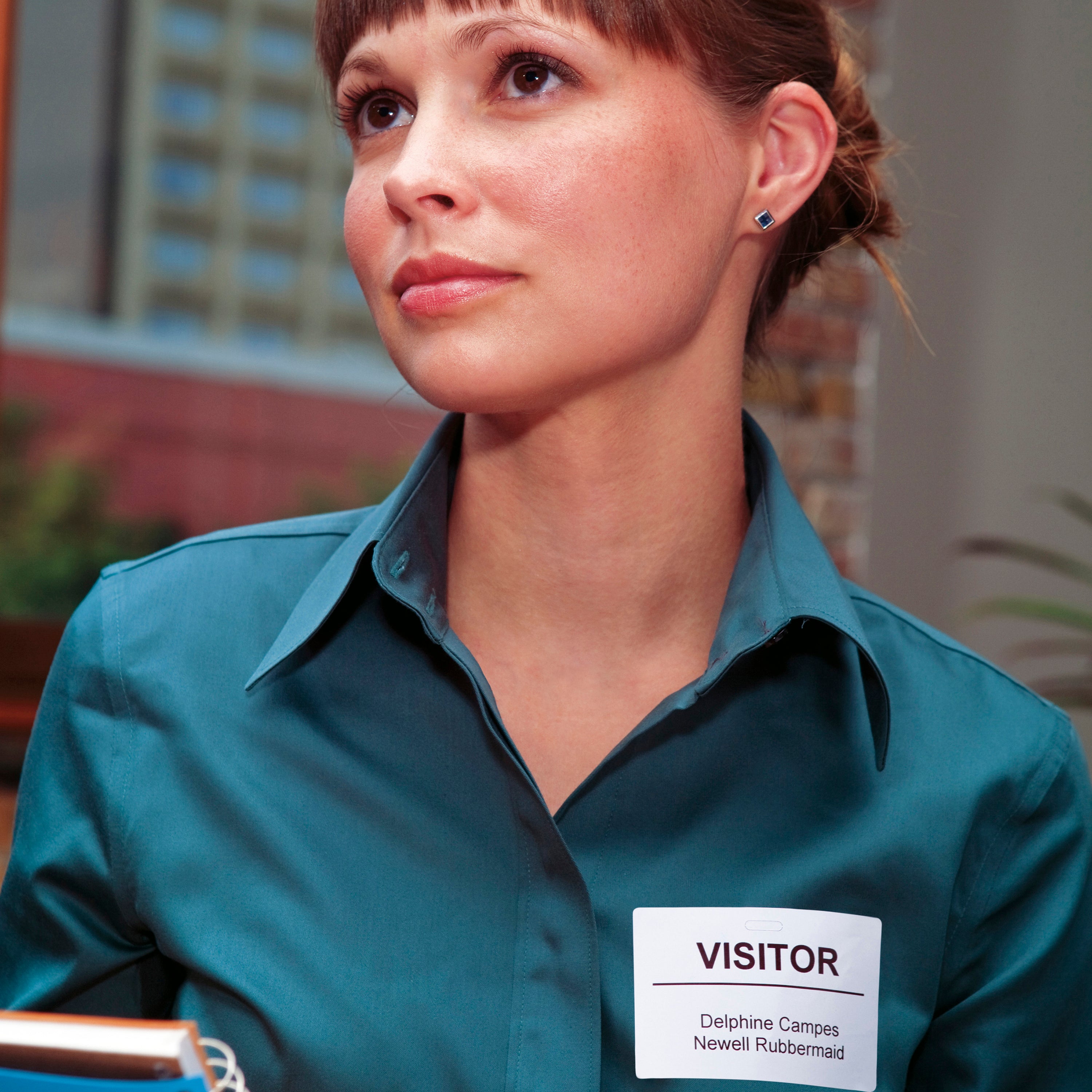 Delivery worker in teal uniform holding parcels