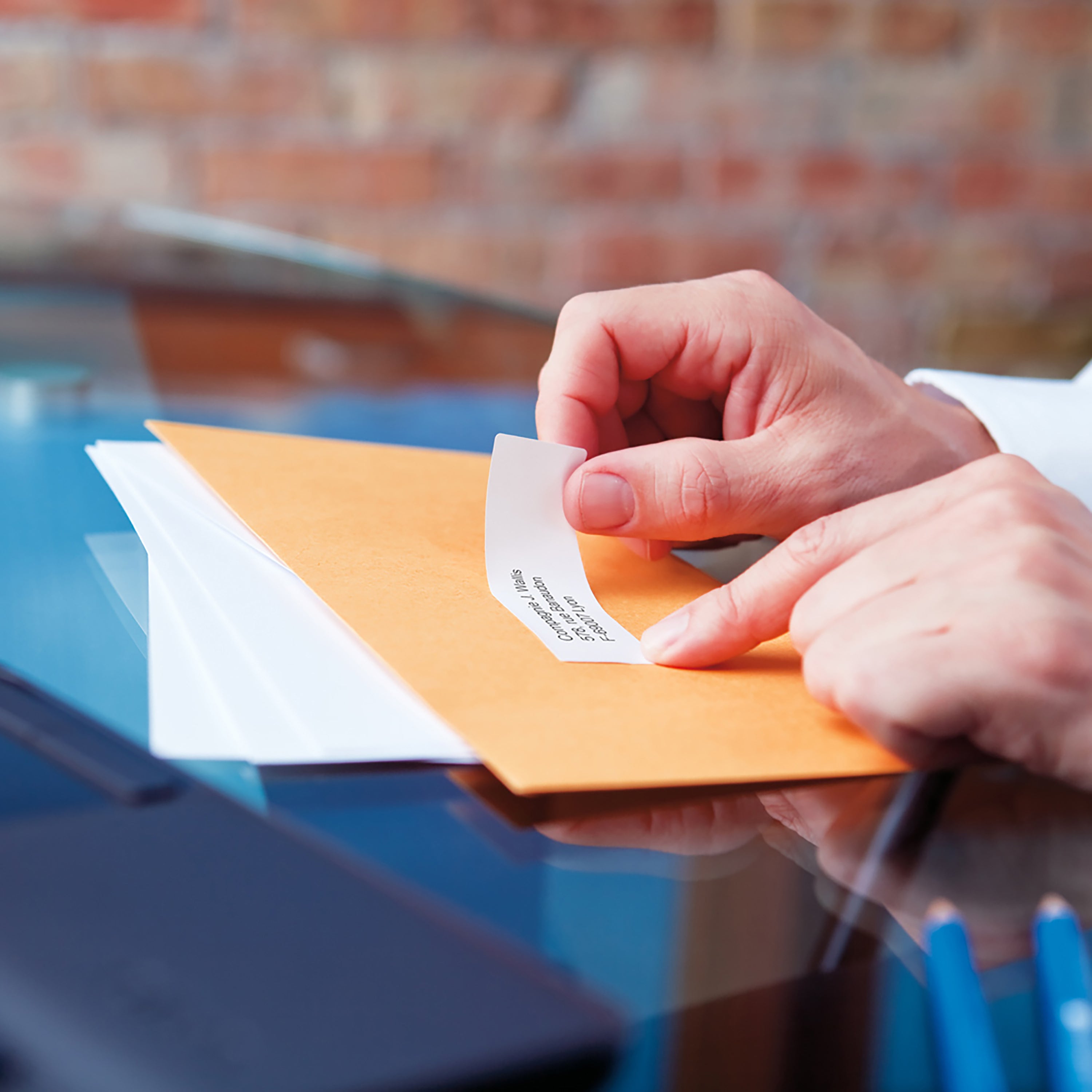 Hand applying a large address label to a parcel box