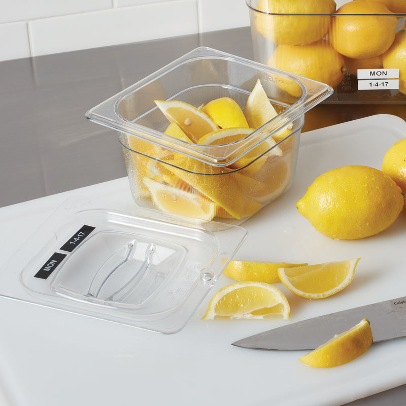 Labelled kitchen jars and food storage containers beside fresh lemons