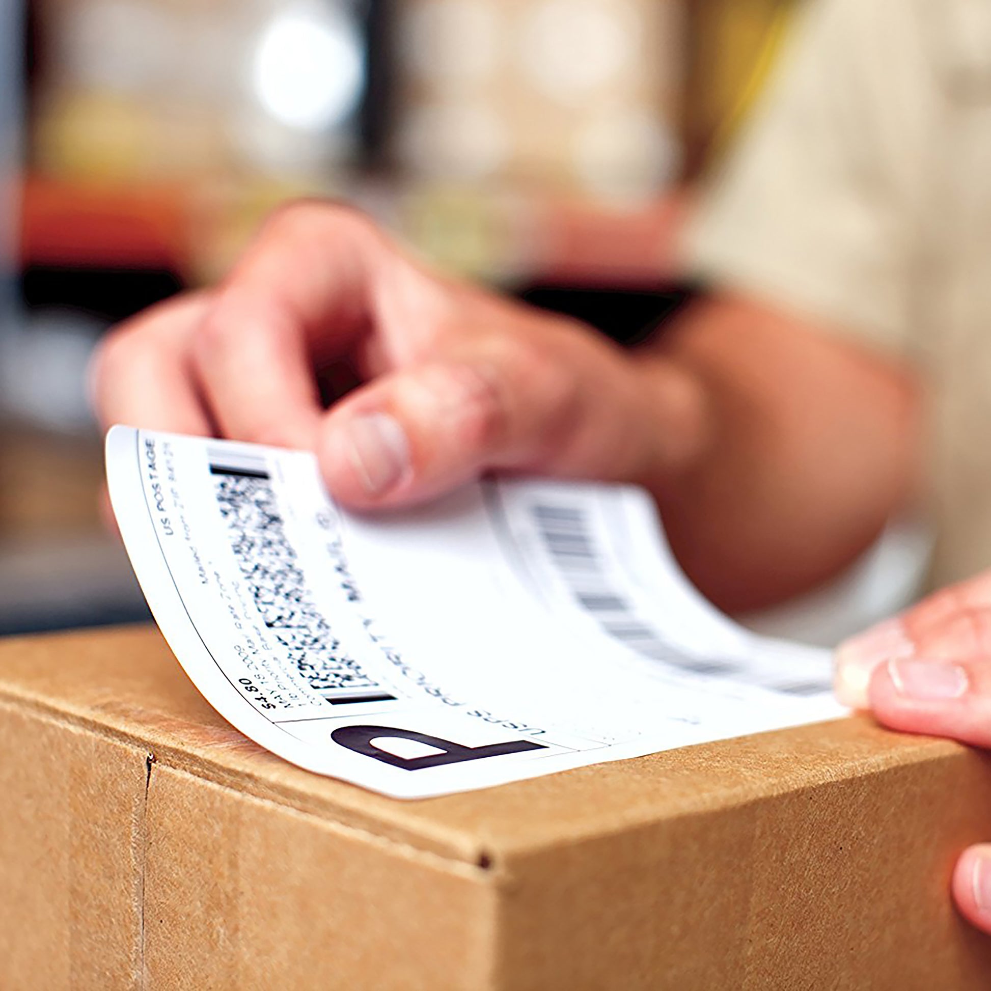Hand placing a label onto a cardboard box