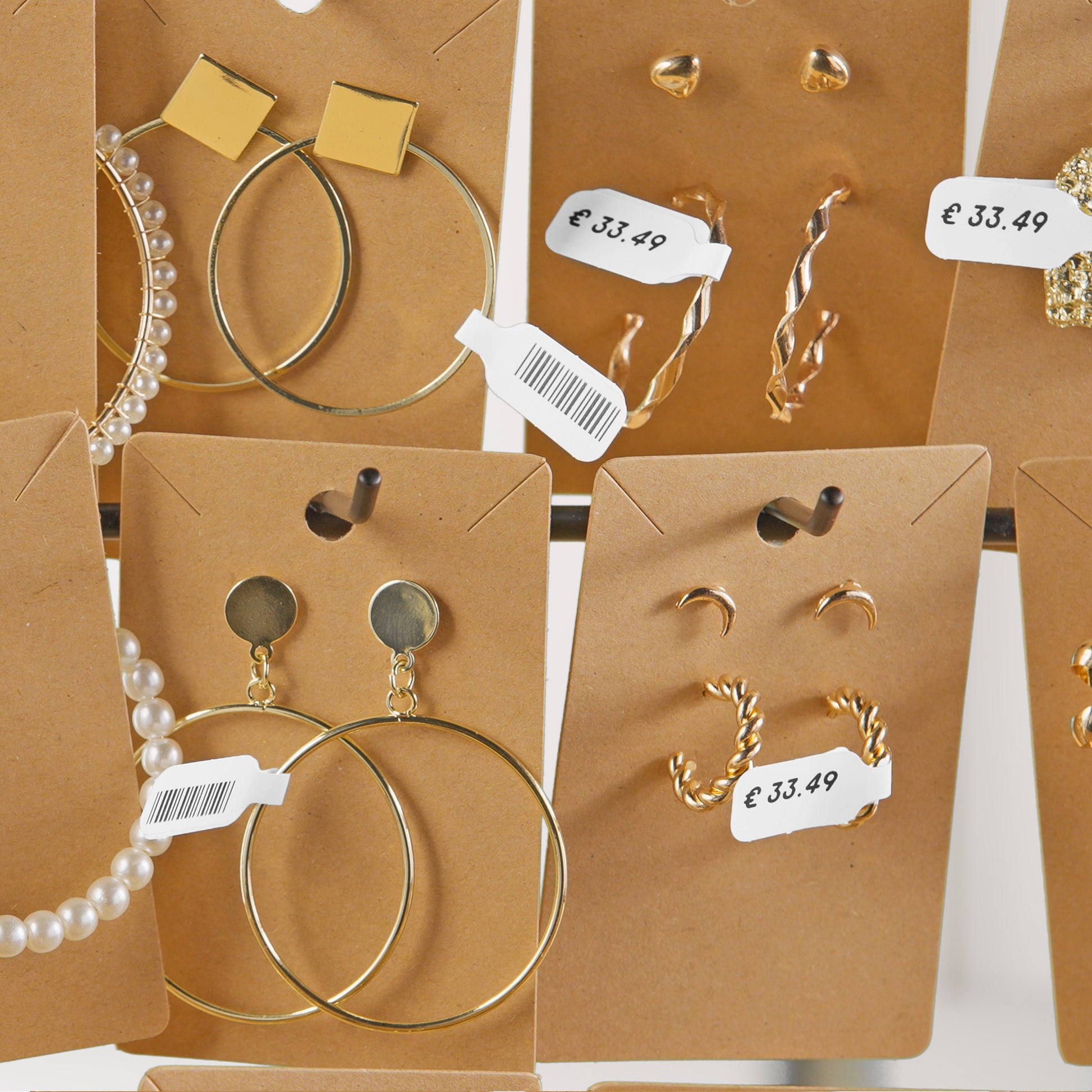 Jewellery display cards with DYMO price and barcode labels attached to earrings and accessories