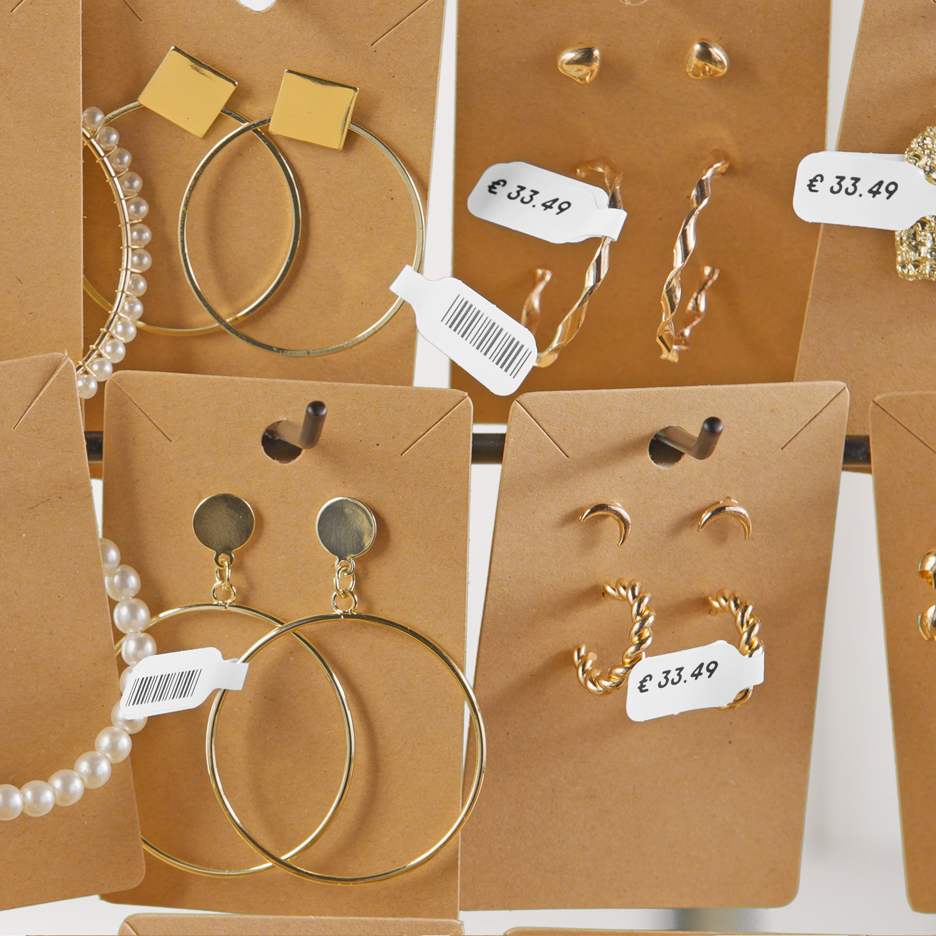 Jewellery display cards with DYMO price and barcode labels attached to earrings and accessories