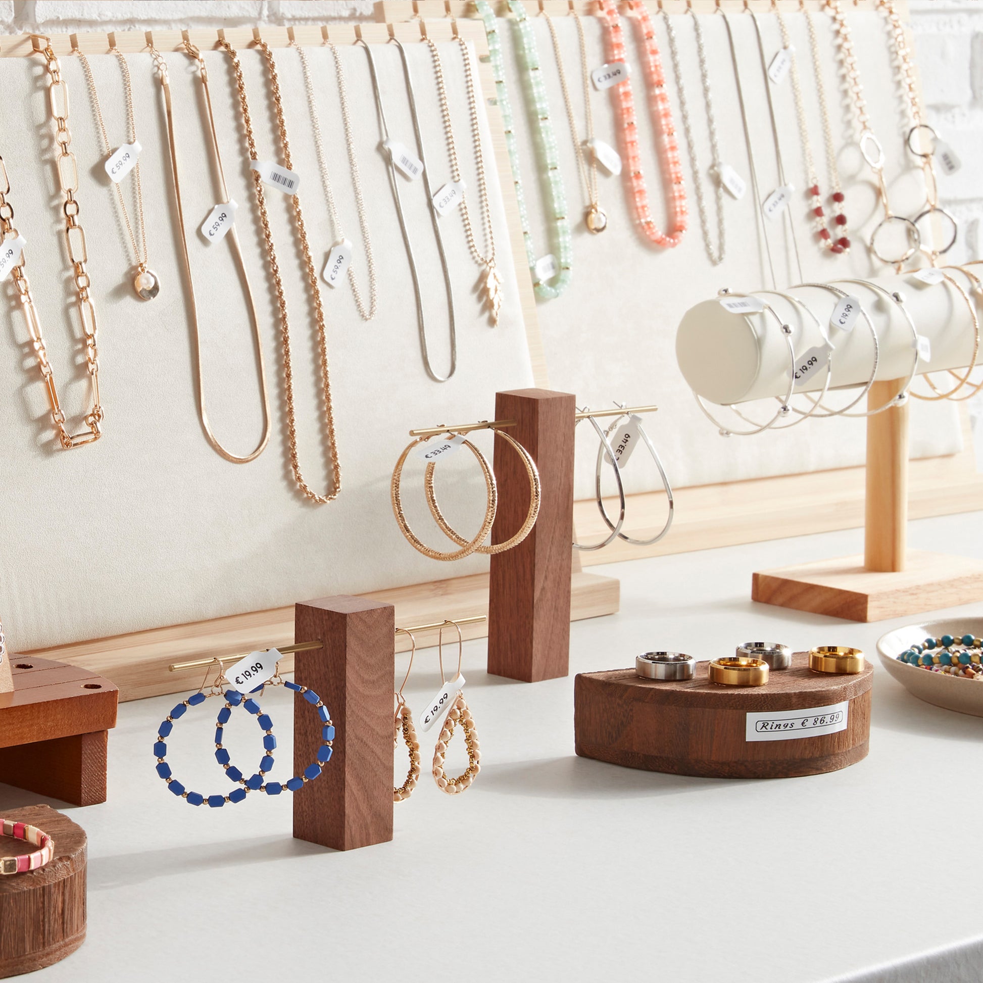 Jewellery display stand with necklaces, earrings, bracelets and rings labelled with DYMO price tags for retail merchandising
