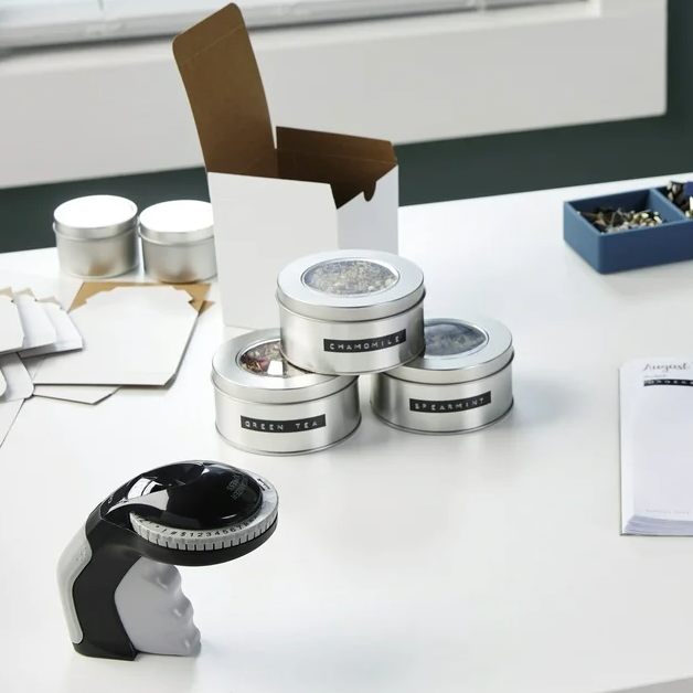DYMO Organizer Xpress Pro embosser on a desk with labelled retail goods