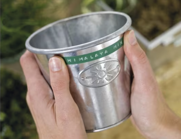 Metal bucket labelled with embossed tape for storage organisation