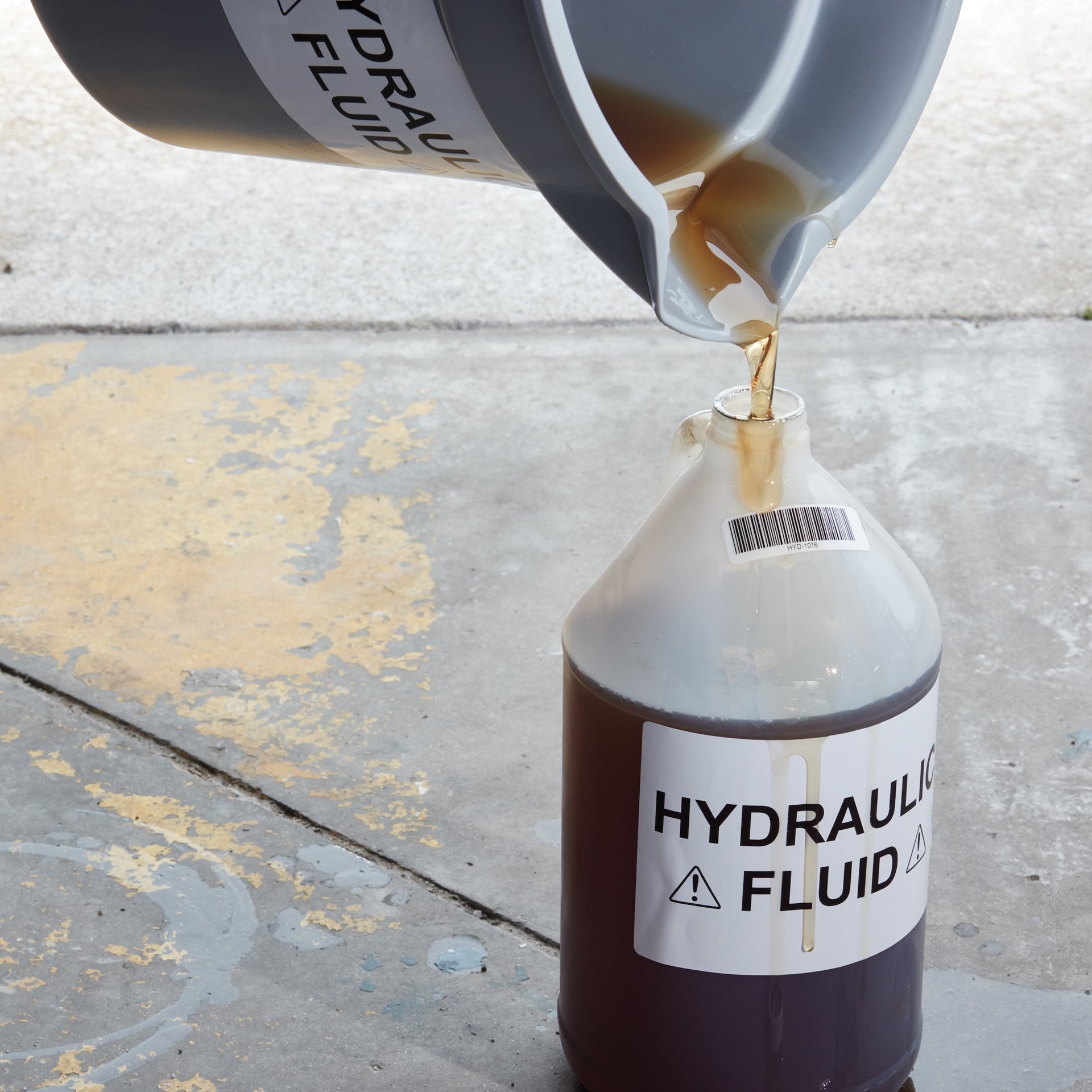 Hydraulic fluid bottle with durable DYMO label applied in an industrial setting