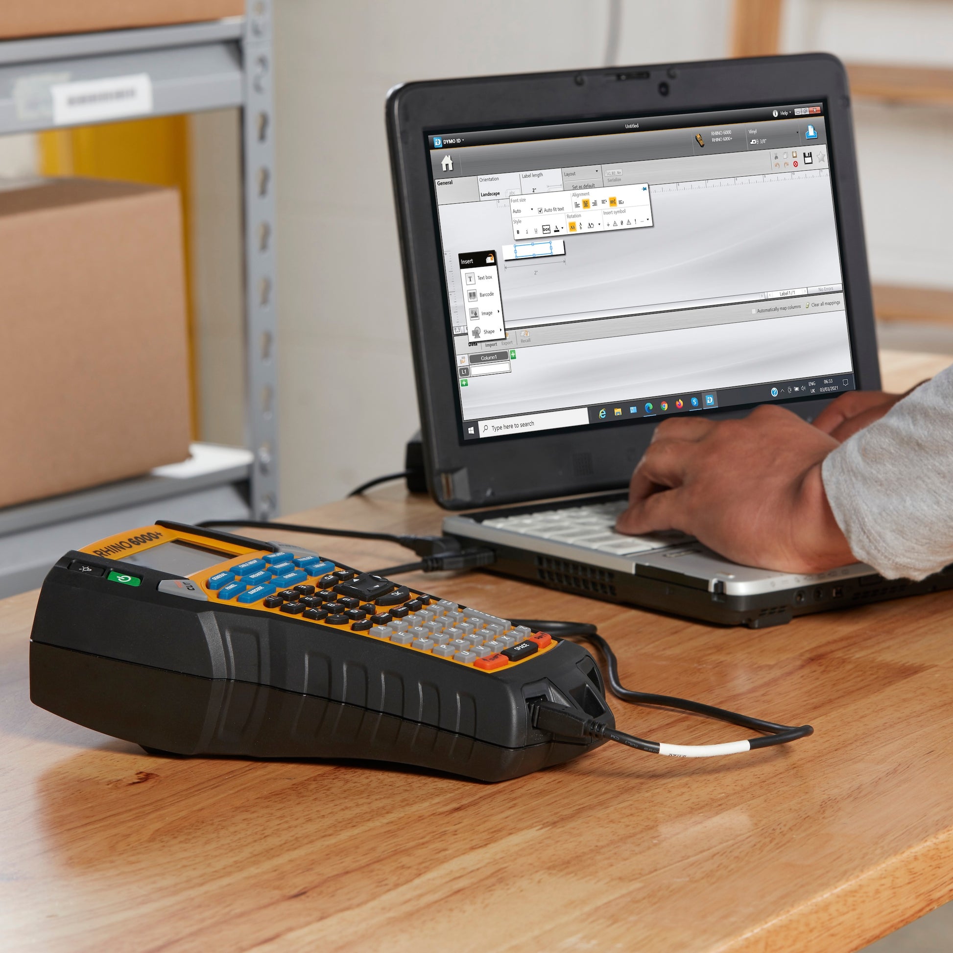 DYMO Rhino 6000 Plus connected to a laptop for PC based industrial label design and printing at a workbench