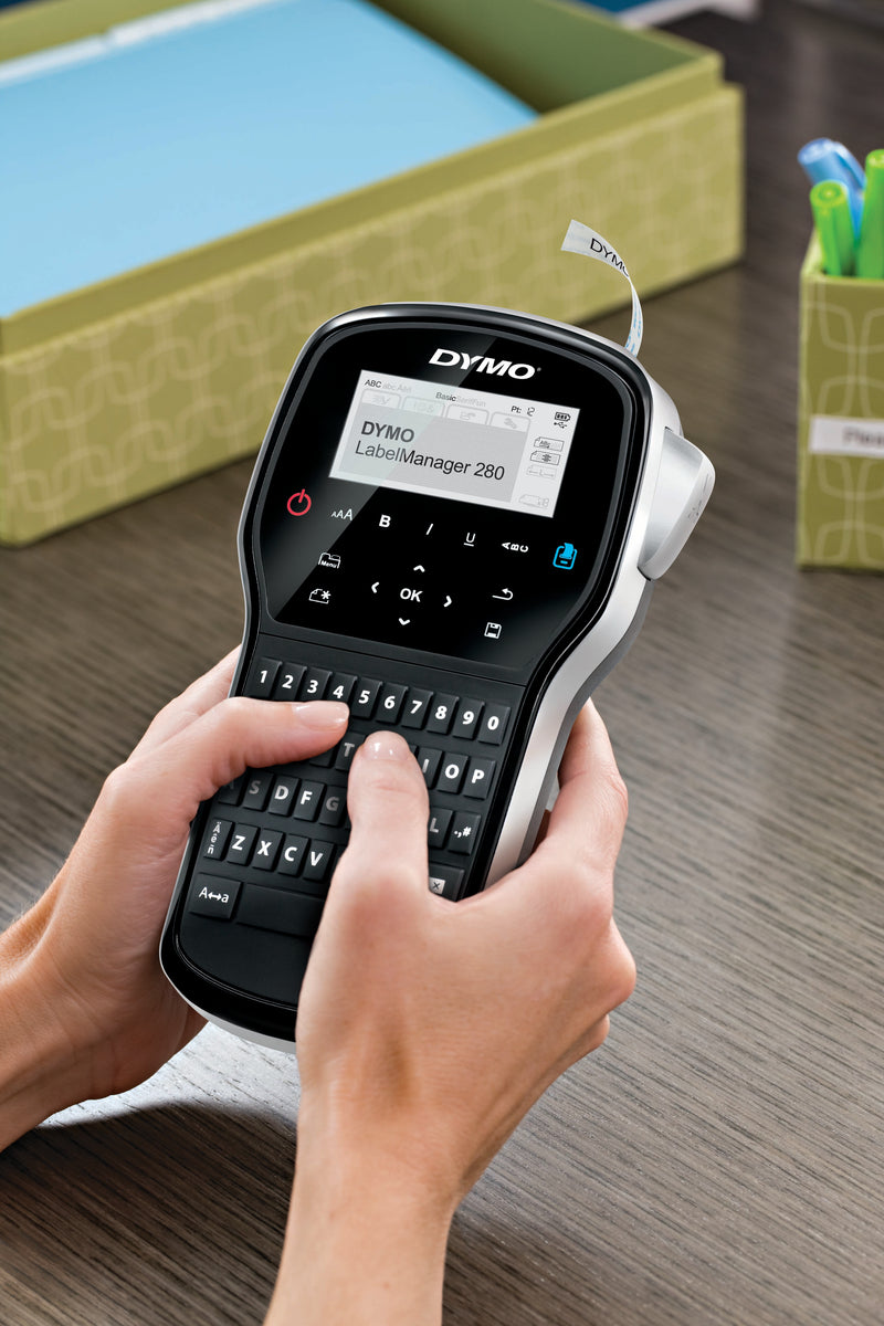 Hands using the DYMO LabelManager 280 handheld label maker at a desk for home or office organisation